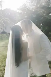 bride and groom sharing a kiss under the veil, with sunlight shining through, at the treasury garden, Melbourne