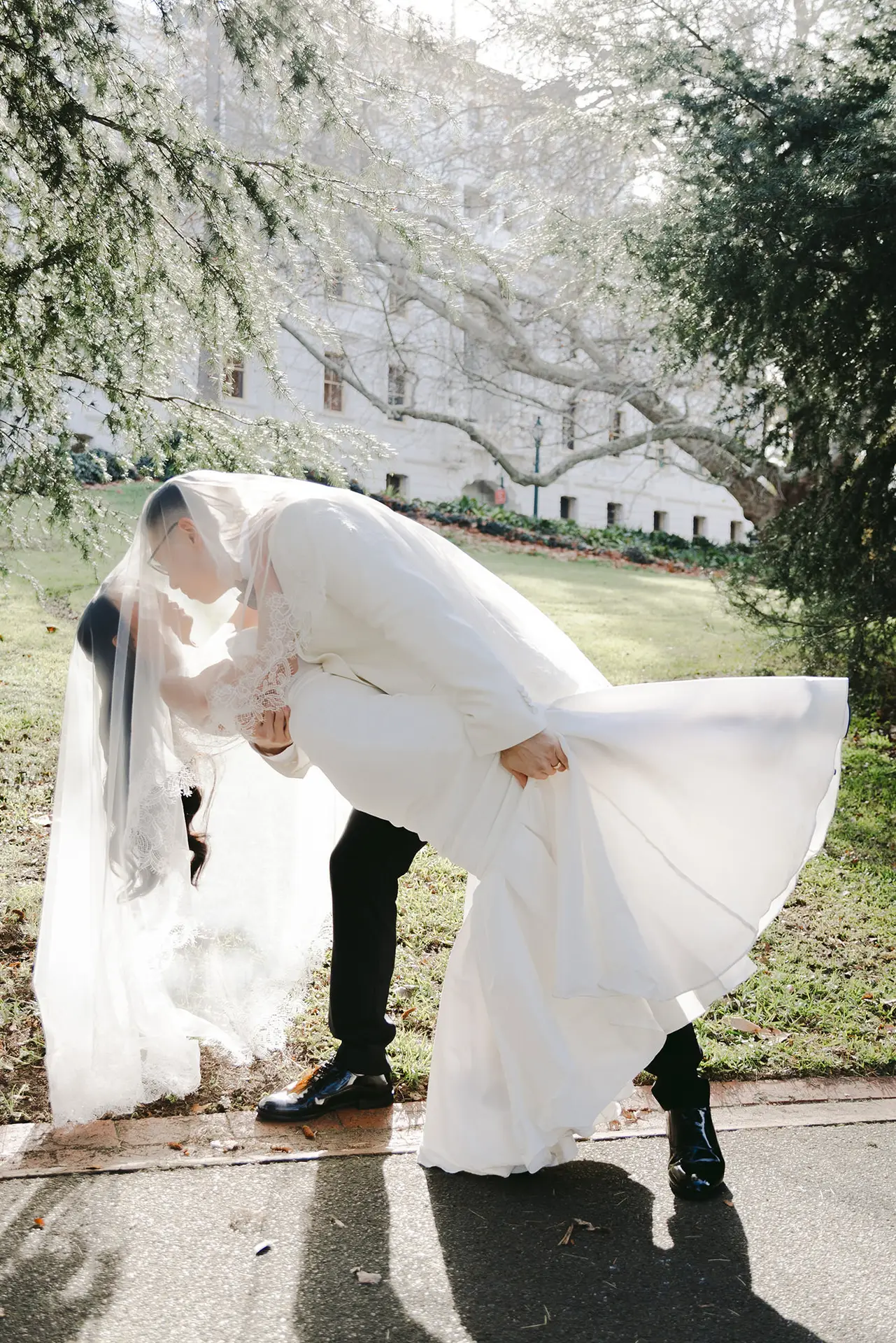 Bride and groom dip kiss at the treasury garden, after their registry wedding at the old treasury building